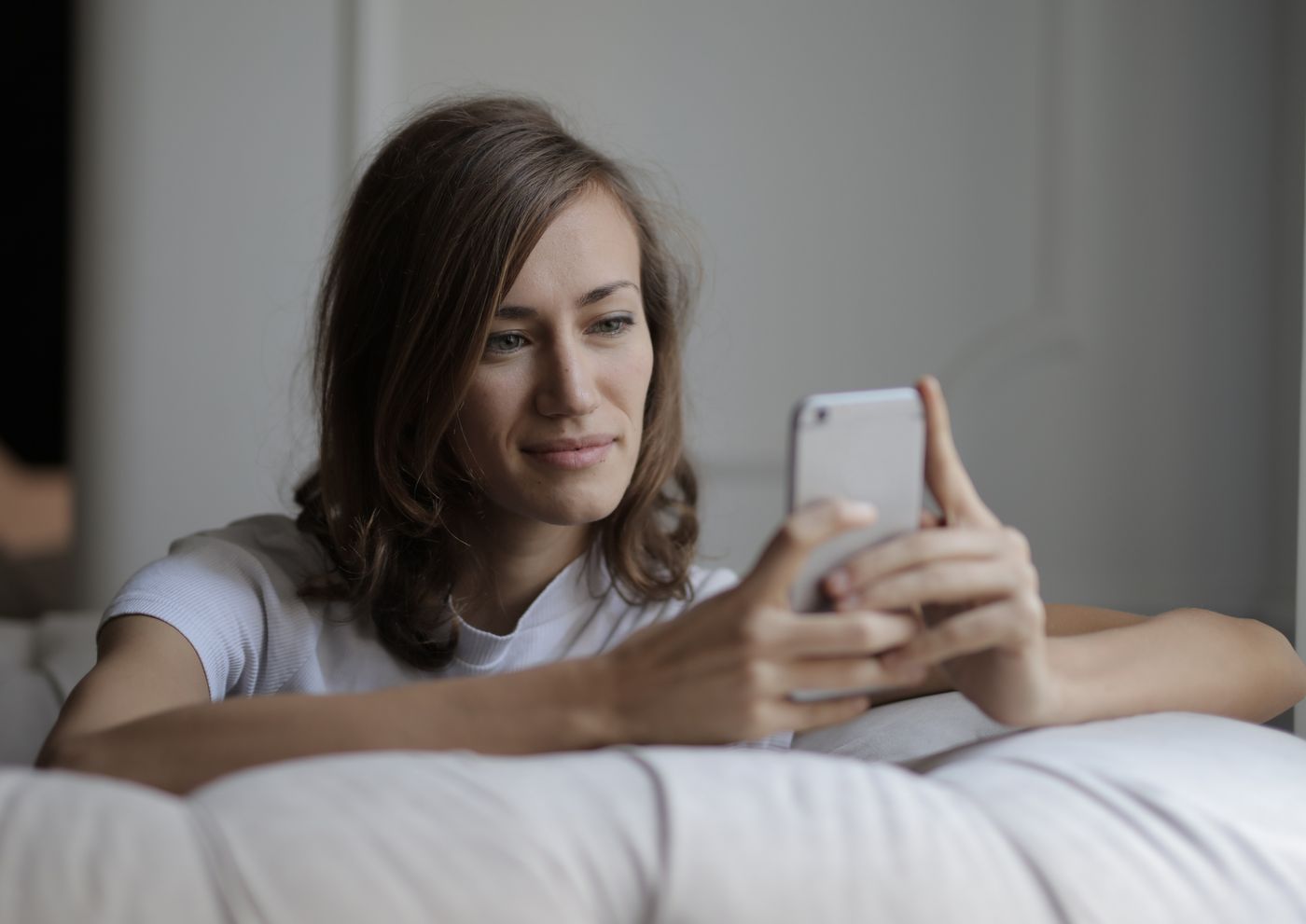 A woman checking her home on her phone from the sofa